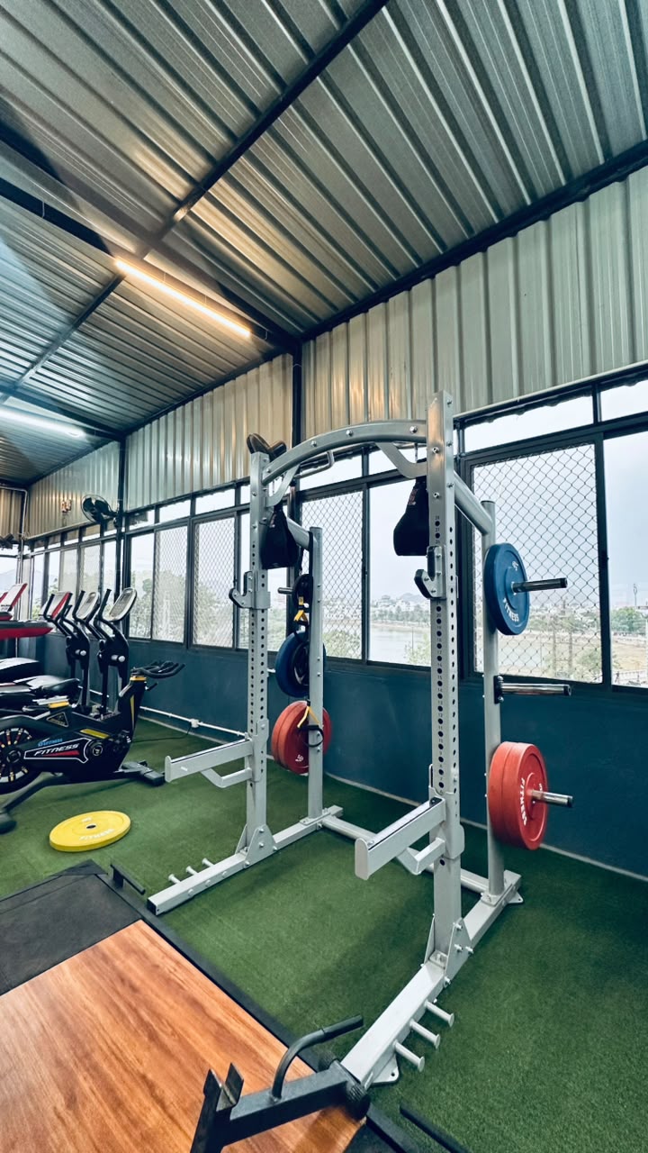 Squat rack and Olympic plates on the rooftop floor